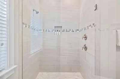a white bathroom with a shower with a glass door at Sunkissed on 30A in Inlet Beach