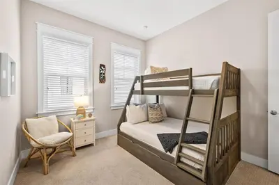 a bedroom with two bunk beds and a chair at Sunkissed on 30A in Inlet Beach