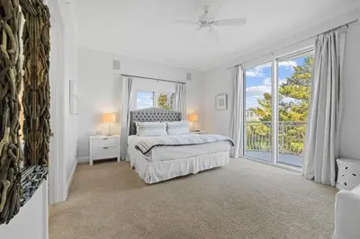 a bedroom with a bed and a large window at The Alexander in Seacrest