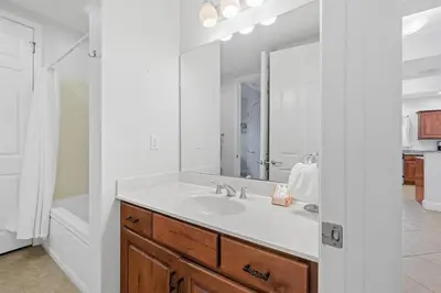 a bathroom with a sink and a large mirror at The Alexander in Seacrest