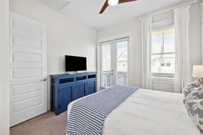 a bedroom with a bed with a blue dresser and a tv at Sea Ya Soon in Inlet Beach