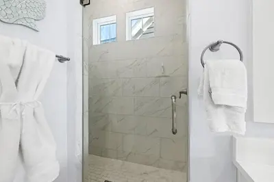 a bathroom with a shower with a glass door at White Sand Dreamin' in Inlet Beach