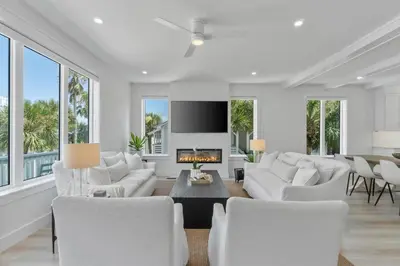 a living room with white furniture and a fireplace at Dune Drifter in Seagrove Beach