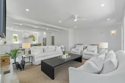 a living room with white furniture and a kitchen at Dune Drifter in Seagrove Beach
