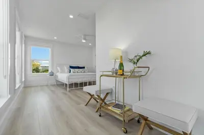 a white living room with a table and a couch at Dune Drifter in Seagrove Beach
