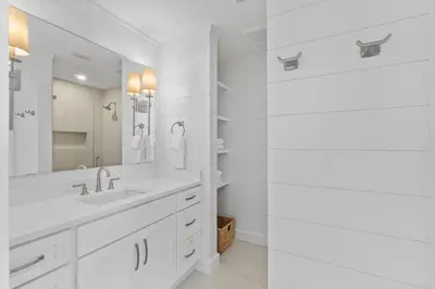 a white bathroom with a sink and a mirror at Dune Drifter in Seagrove Beach