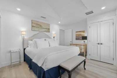 a white bedroom with a large bed and a table at Dune Drifter in Seagrove Beach