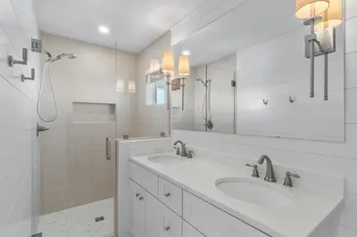 a white bathroom with two sinks and a mirror at Dune Drifter in Seagrove Beach