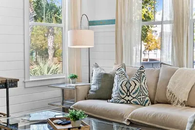 a couch in a living room with windows at It's a Shore Thing in Inlet Beach