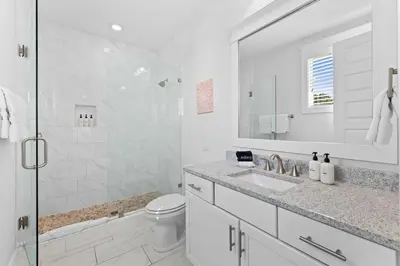 a white bathroom with a shower and a sink at It's a Shore Thing in Inlet Beach