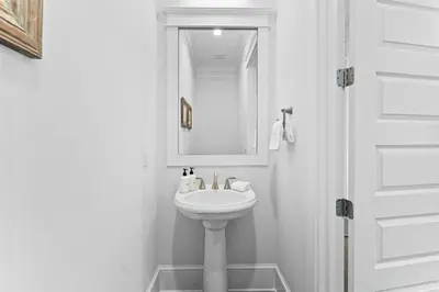 a white bathroom with a sink and a mirror at It's a Shore Thing in Inlet Beach