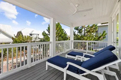 a porch with blue chairs and a view of the ocean at It's a Shore Thing in Inlet Beach