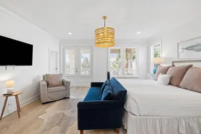 a bedroom with a bed and a couch and a tv at A Lovely Stay on 30A in Seacrest