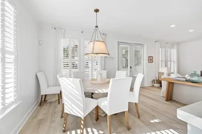 a dining room with a table and white chairs at A Lovely Stay on 30A in Seacrest