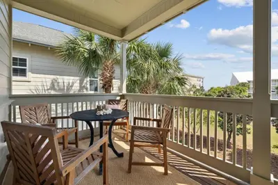 a patio with a table and chairs on a balcony at Resting Beach Place in Inlet Beach