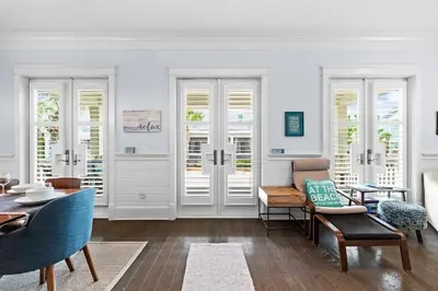 a living room with white walls and a table and chairs at Sol Mates in Inlet Beach