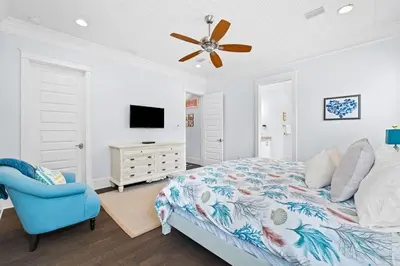 a bedroom with a bed and a blue chair at Sol Mates in Inlet Beach