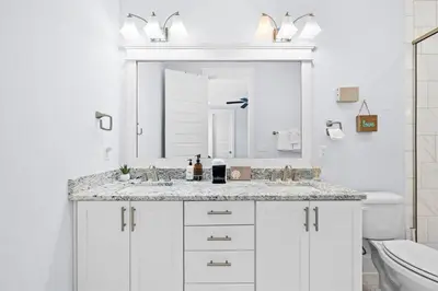 a white bathroom with a sink and a mirror at Sol Mates in Inlet Beach