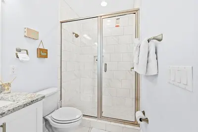 a white bathroom with a shower and a toilet at Sol Mates in Inlet Beach