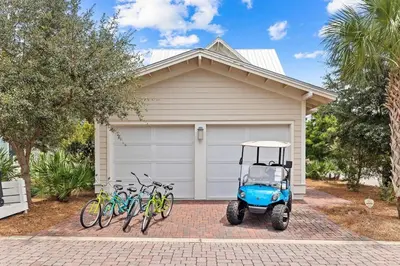 a golf cart parked in front of a house with bikes at Sol Mates in Inlet Beach
