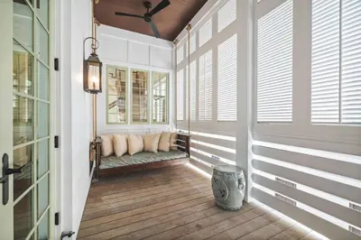 a porch with a bench in a room with windows at Sadie's Cottage in Rosemary Beach