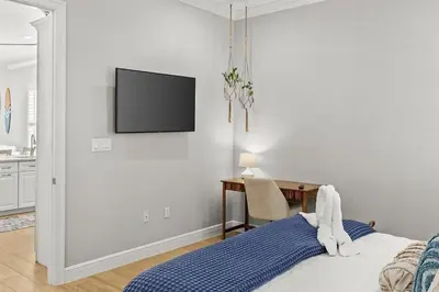 a bedroom with a bed and a desk with a television on the wall at Sweet Bay on 30A in Seagrove Beach