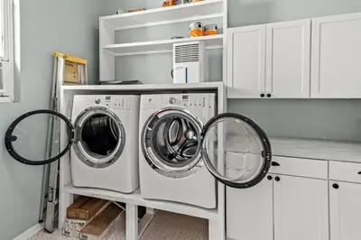 two washing machines in a kitchen with white cabinets at Sweet Bay on 30A in Seagrove Beach