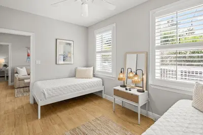 a white room with a bed and a mirror at Sweet Bay on 30A in Seagrove Beach