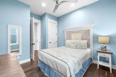 a bedroom with blue walls and a bed and a lamp at Southern Comfort in Seacrest