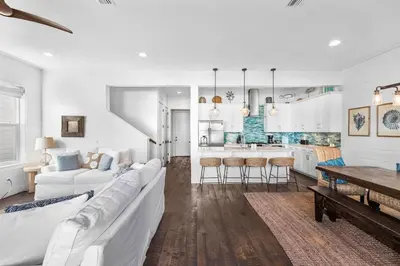 a living room with a white couch and a kitchen at Southern Comfort in Seacrest