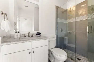 a white bathroom with a toilet and a shower at The Last Waltz in Seacrest