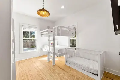 a white nursery with a crib and bunk beds at The Last Waltz in Seacrest