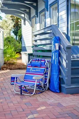 a blue lawn chair sitting in front of a house at The Last Waltz in Seacrest