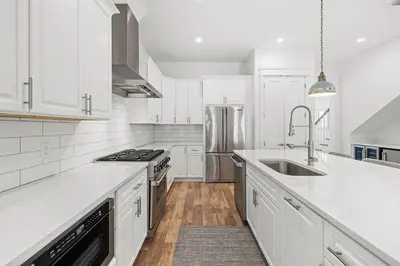 a white kitchen with a sink and a refrigerator at Villa Bianca in Seacrest