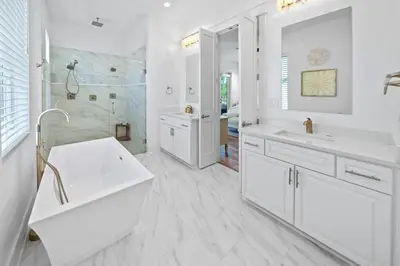 a white bathroom with two sinks and a shower at Villa Bianca in Seacrest