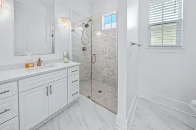a white bathroom with a shower and a sink at Villa Bianca in Seacrest