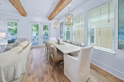 a dining room with a table and chairs and windows at Villa Bianca in Seacrest