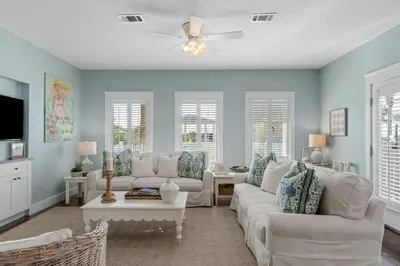 a living room with white furniture and blue walls at Seahorse Landing in Seagrove Beach
