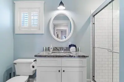 a white bathroom with a sink and a mirror at Seahorse Landing in Seagrove Beach
