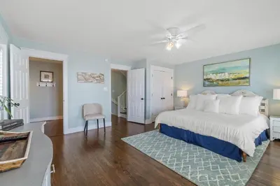 a large bedroom with a bed and a chair at Seahorse Landing in Seagrove Beach