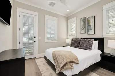 a bedroom with a large bed and two windows at Casa de Sol in Inlet Beach