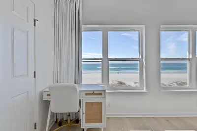 a desk and a chair in a room with windows at Gulfs Edge Townhome #7- Sun-Kissed Memories by Emerald Coast Retreats in Panama City Beach
