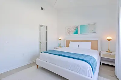 a white bedroom with a large bed and two lamps at Gulfs Edge Townhome #7- Sun-Kissed Memories by Emerald Coast Retreats in Panama City Beach