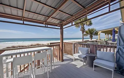 a deck with chairs and a view of the beach at Gulfs Edge Townhome #7- Sun-Kissed Memories by Emerald Coast Retreats in Panama City Beach