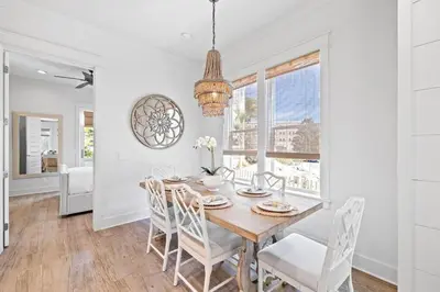 a white dining room with a wooden table and chairs at Sweet Southern Charm in Seacrest