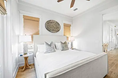a white bedroom with a large white bed with pillows at Sweet Southern Charm in Seacrest