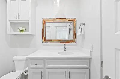 a white bathroom with a sink and a mirror at Sweet Southern Charm in Seacrest