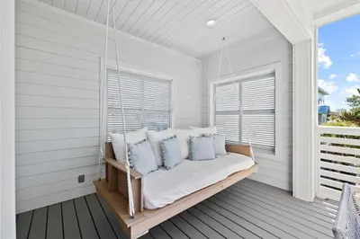 a porch with a bed with pillows and a window at Sweet Southern Charm in Seacrest