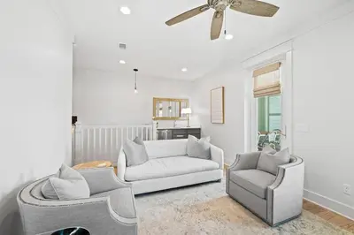 a living room with two chairs and a ceiling fan at Sweet Southern Charm in Seacrest