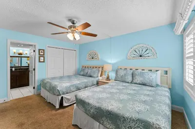 a bedroom with two beds and a ceiling fan at Mariner West #403 in Panama City Beach
